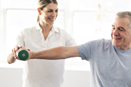 A man doing arm strengthening exercises using a dumbbell with the help of a physiotherapist
